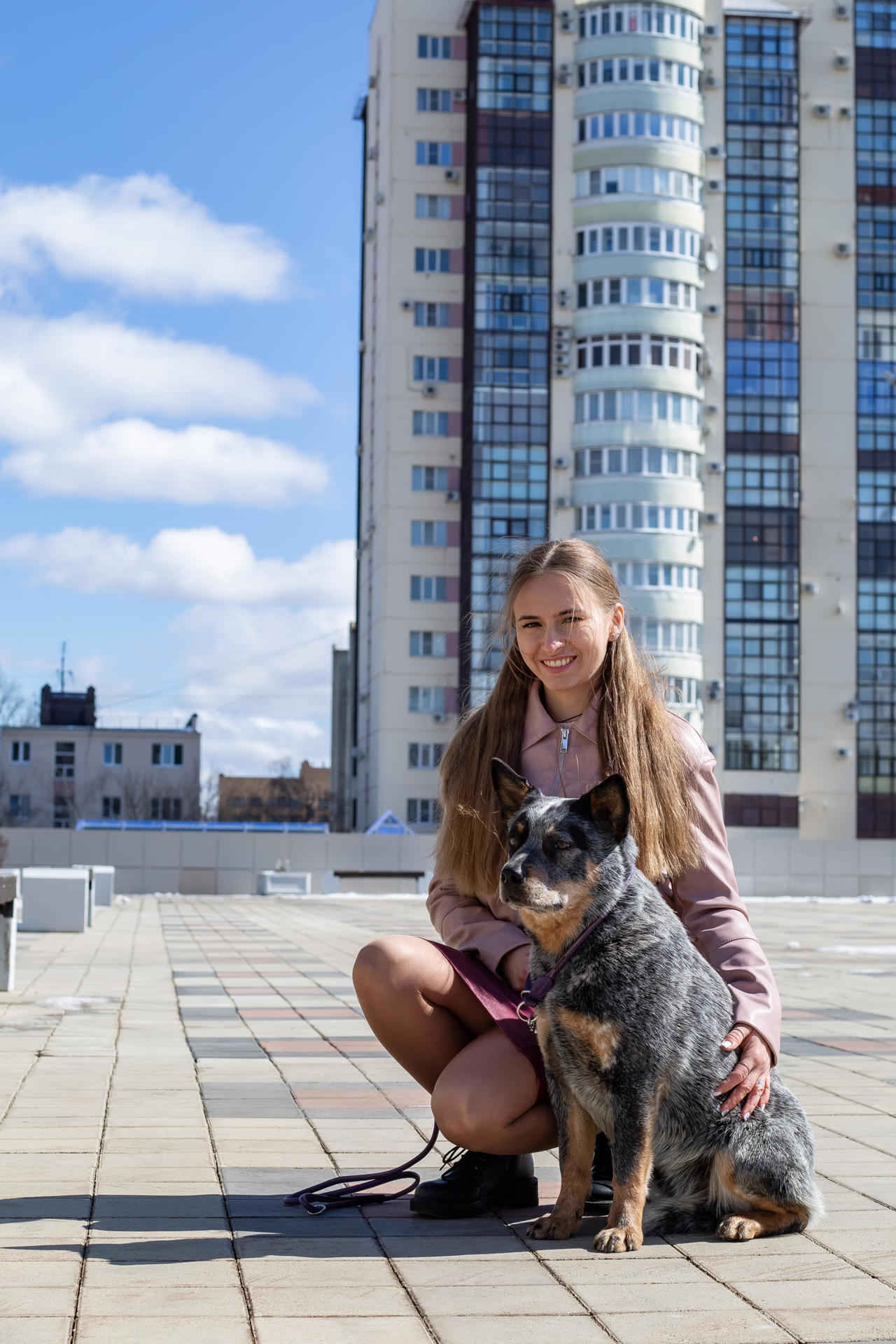 Foto de un perro y una mujer en la ciudad